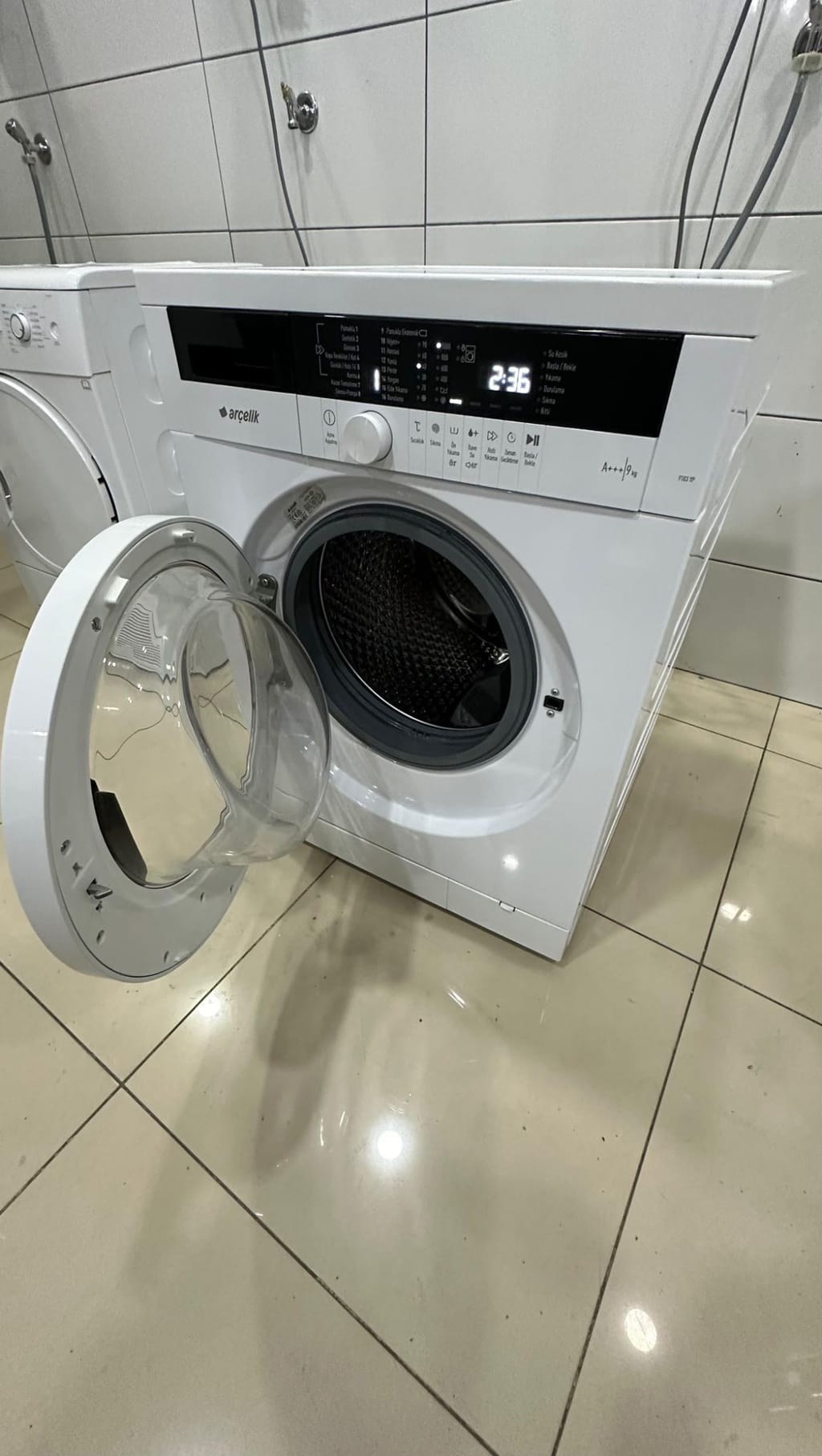 Atölyede kapağı açılarak test edilen ikinci el çamaşır makinesi